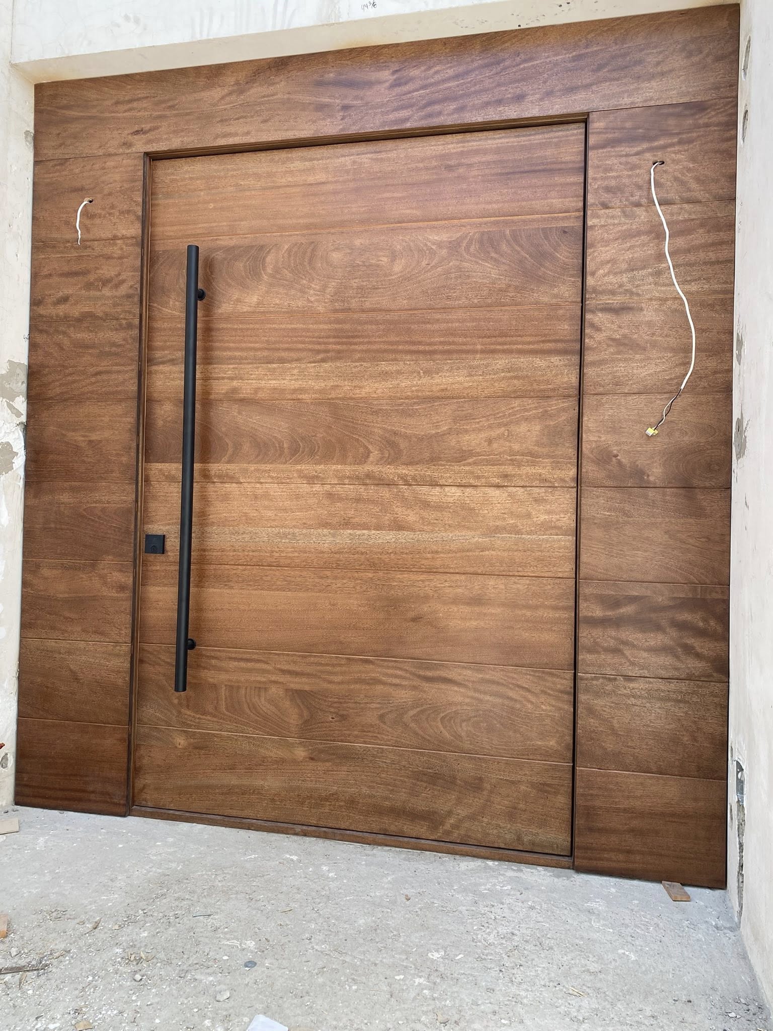 Puerta pivote gran formato en nogal / Large format walnut pivot door installed