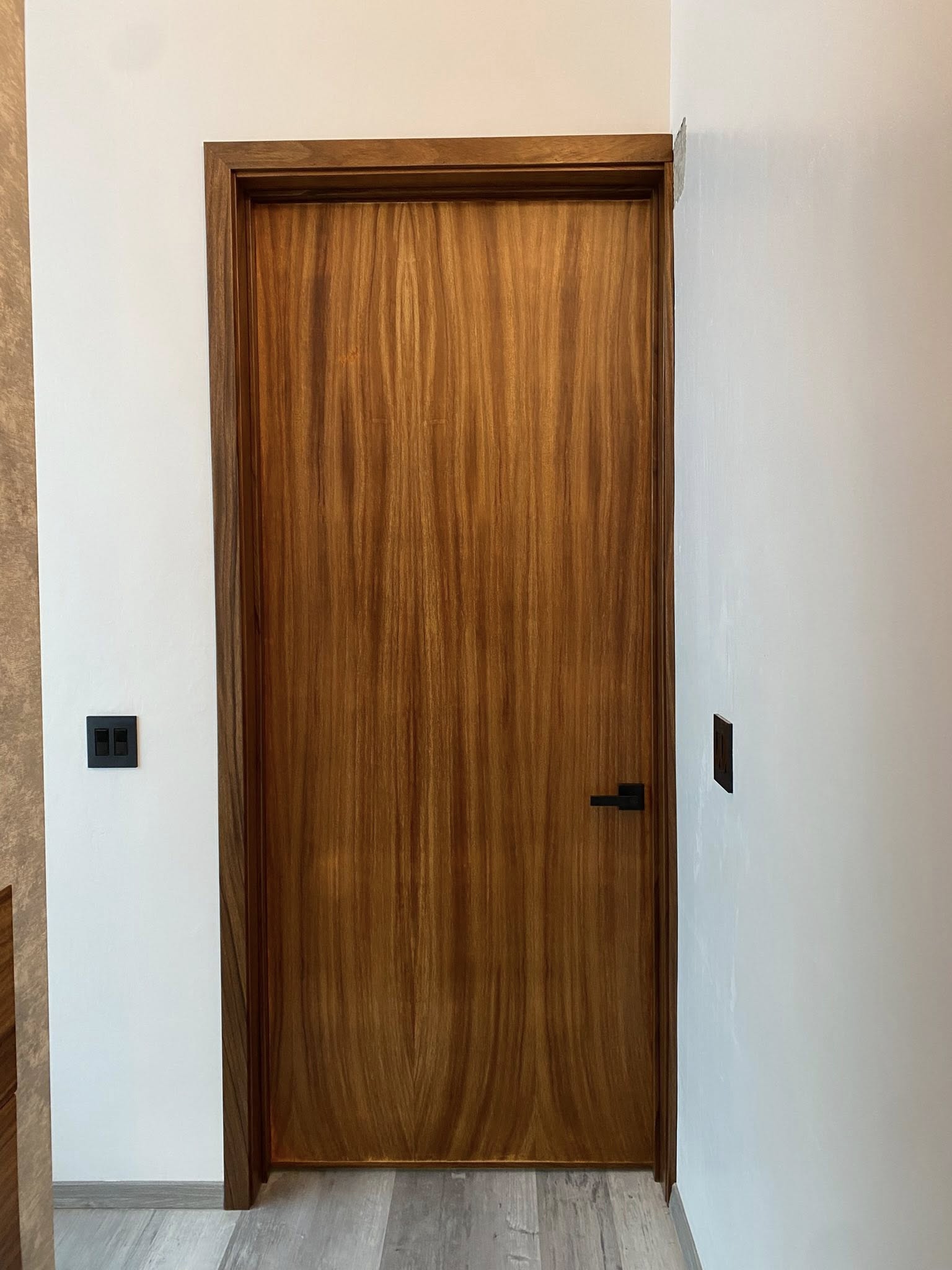 Puerta interior parota en pared de concreto / Parota door with concrete textured wall